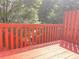 A red wooden deck with trees in the background at 795 Abbotts Mill Ct # 73, Johns Creek, GA 30097