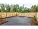 The gravel backyard is enclosed by a wooden fence and surrounded by greenery at 11560 Serenbe Ln, Chattahoochee Hills, GA 30268