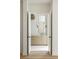 Bathroom with a natural-tone vanity and sconces seen through an open door at 11560 Serenbe Ln, Chattahoochee Hills, GA 30268