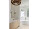 Lovely bathroom with vanity, gold hardware, and a luxurious soaking tub and views at 11560 Serenbe Ln, Chattahoochee Hills, GA 30268