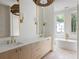 Bathroom with double vanity, sconces, and a soaking tub with a view at 11560 Serenbe Ln, Chattahoochee Hills, GA 30268