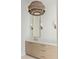 Stylish bathroom featuring a wood-toned vanity, gold hardware and a designer light fixture at 11560 Serenbe Ln, Chattahoochee Hills, GA 30268