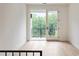 Bright bedroom with hardwood floors and a private balcony overlooking a lush green landscape at 11560 Serenbe Ln, Chattahoochee Hills, GA 30268