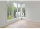 Bedroom with large windows offering natural light and scenic views of the surrounding lush greenery at 11560 Serenbe Ln, Chattahoochee Hills, GA 30268