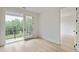 This bright bedroom with hardwood floors has a private balcony overlooking a lush green landscape at 11560 Serenbe Ln, Chattahoochee Hills, GA 30268