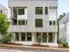 Contemporary townhome with striking architectural details, including wood siding, black windows, and manicured landscaping at 11560 Serenbe Ln, Chattahoochee Hills, GA 30268