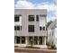 Modern townhouse showcasing striking wood siding, sleek black windows, and inviting glass-panel doors at 11560 Serenbe Ln, Chattahoochee Hills, GA 30268