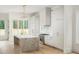 Bright kitchen featuring a marble island, stainless steel appliances, and stylish pendant lighting at 11560 Serenbe Ln, Chattahoochee Hills, GA 30268