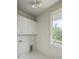 Laundry room with stylish herringbone floors and natural light from large window at 11560 Serenbe Ln, Chattahoochee Hills, GA 30268