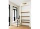 Staircase next to wall with built in shelves, near light-filled windows and glass-paneled doors at 11560 Serenbe Ln, Chattahoochee Hills, GA 30268