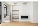 Bright living room featuring light wood floors, a marble fireplace, and custom built-in shelving at 11560 Serenbe Ln, Chattahoochee Hills, GA 30268