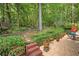Scenic backyard with a stone pathway, lush plantings, and an outdoor dining area for relaxation at 3245 Bywater Trl, Roswell, GA 30075