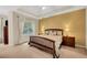 Bedroom featuring neutral carpet, tray ceiling, and window with natural light at 3245 Bywater Trl, Roswell, GA 30075