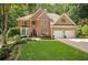 Beautifully landscaped front yard of a brick home with mature trees at 3245 Bywater Trl, Roswell, GA 30075
