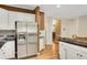 Kitchen area boasting stainless steel refrigerator and white cabinets, plus hardwood floors and sleek countertops at 3245 Bywater Trl, Roswell, GA 30075