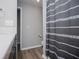 Bathroom featuring gray walls, wood-look flooring, shower with decorative curtain, and white vanity sink at 325 Berry Ct, Villa Rica, GA 30180