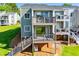 Exterior featuring double balconies, glass sliding doors, staircase to the backyard, and beautiful landscaping at 325 Berry Ct, Villa Rica, GA 30180