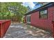 An outdoor wooden deck with a red railing offers an exterior view of the home at 4246 Rue Saint Michel, Stone Mountain, GA 30083