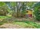 A backyard view of home with wood deck and stairs surrounded by beautiful greenery at 4246 Rue Saint Michel, Stone Mountain, GA 30083