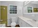 Bright bathroom features a white vanity with sink, toilet, mirror, tiled wall, and wood floor at 4246 Rue Saint Michel, Stone Mountain, GA 30083