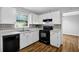 Cozy kitchen features white cabinets, stainless appliances, and stylish backsplash with hardwood floors at 4246 Rue Saint Michel, Stone Mountain, GA 30083