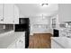 Bright kitchen featuring white cabinets, stainless appliances, and stylish backsplash with hardwood floors at 4246 Rue Saint Michel, Stone Mountain, GA 30083