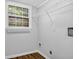 Laundry room with metal shelving, hardwood floors, and natural light from a window at 4246 Rue Saint Michel, Stone Mountain, GA 30083