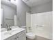 Bright bathroom features a single sink vanity, toilet, and shower-tub combination with white tile surround at 2685 Peachtree Walk Walk, Duluth, GA 30096