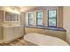 Bright bathroom with a standalone tub, modern vanity, and multiple windows offering natural light at 2685 Peachtree Walk Walk, Duluth, GA 30096