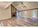 Bright living room featuring a stone fireplace, vaulted ceiling, ceiling fan, and wood-look flooring at 2685 Peachtree Walk Walk, Duluth, GA 30096