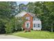 Charming two-story home featuring a well-manicured lawn, brick facade, blue shutters, and lush landscaping at 3152 Andora Sw Trl, Marietta, GA 30064