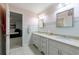 Bright bathroom featuring double sinks, neutral countertops, and decorative wallpaper at 525 Avala Ct, Johns Creek, GA 30022