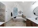 Luxurious bathroom featuring a chandelier, soaking tub, modern vanity, and custom tile accents at 525 Avala Ct, Johns Creek, GA 30022