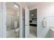 Connected bathroom with shower and toilet, white cabinets and pink wallpaper at 525 Avala Ct, Johns Creek, GA 30022