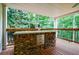 Close up of a stone grilling station on the covered deck with wooded views at 525 Avala Ct, Johns Creek, GA 30022