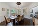 Bright dining room featuring a chandelier, hardwood floors, and large shuttered windows at 525 Avala Ct, Johns Creek, GA 30022