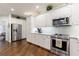 Well-lit kitchen with stainless steel appliances, white cabinets, and tiled backsplash at 525 Avala Ct, Johns Creek, GA 30022