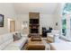 Bright living room showcasing a stone fireplace, wet bar and a comfortable seating area at 525 Avala Ct, Johns Creek, GA 30022