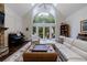 Bright living room featuring hardwood floors, piano, arched window and large white sofa at 525 Avala Ct, Johns Creek, GA 30022