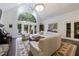 Bright living room with large arched window, hardwood floors, white sofa, and access to the deck at 525 Avala Ct, Johns Creek, GA 30022