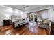 Relaxing main bedroom with hardwood floors, french doors to balcony, and a comfortable sitting area at 525 Avala Ct, Johns Creek, GA 30022