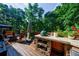 Spacious outdoor kitchen with built-in grill on a wooden deck overlooking lush greenery at 525 Avala Ct, Johns Creek, GA 30022