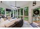 Cozy screened porch with comfortable seating, ceiling fan, and a view of the lush greenery at 525 Avala Ct, Johns Creek, GA 30022