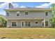 Back exterior view with large windows, a grassy area and lots of green trees at 5705 Cannonero Dr Dr, Alpharetta, GA 30005