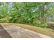 Backyard featuring a concrete patio surrounded by green trees and landscaping at 5705 Cannonero Dr Dr, Alpharetta, GA 30005