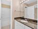 Bathroom with granite countertop vanity, large mirror, white cabinets, and bathtub with white tiling at 5705 Cannonero Dr Dr, Alpharetta, GA 30005