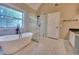 Modern bathroom featuring a freestanding tub, glass-enclosed shower, marble floors, and a large window at 5705 Cannonero Dr Dr, Alpharetta, GA 30005
