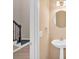This powder room features a neutral paint, white sink, a mirror, and sconce lighting at 5705 Cannonero Dr Dr, Alpharetta, GA 30005