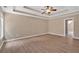 Spacious bedroom with a tray ceiling, wood-look floors, a ceiling fan, and ample natural light at 5705 Cannonero Dr Dr, Alpharetta, GA 30005