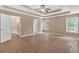 Spacious bedroom with wood-look flooring, tray ceiling, fan, and natural light at 5705 Cannonero Dr Dr, Alpharetta, GA 30005